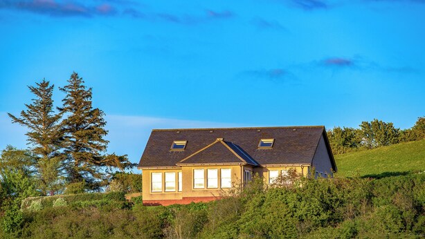 A house with a sloped roof, two windows on the front, and surrounded by greenery. - 4 bedroom accommodation in Lendalfoot, near Girvan (Lendalfoot, near Girvan)
