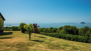A grassy lawn with a view of the sea and a distant island. - 4 bedroom accommodation in Lendalfoot, near Girvan (Lendalfoot, near Girvan)