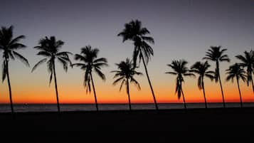 Una playa cerca, sillas reclinables de playa, toallas de playa