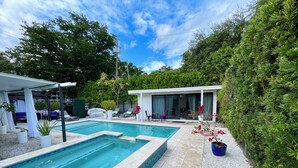 A private pool area with a covered seating area and a modern house in the background. - Ohhh-Our sweet little surprise #TinyPoolHouse #MiamiDesignDistrict (Miami)