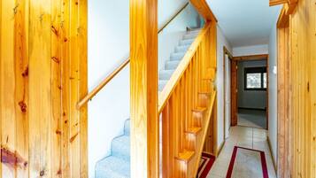A wooden staircase with a handrail and a carpeted floor.