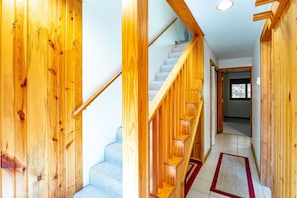 A wooden staircase with a handrail and a carpeted floor.