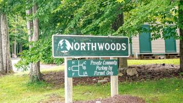 A sign indicating NORTHWOODS as a private community with parking by permit only.