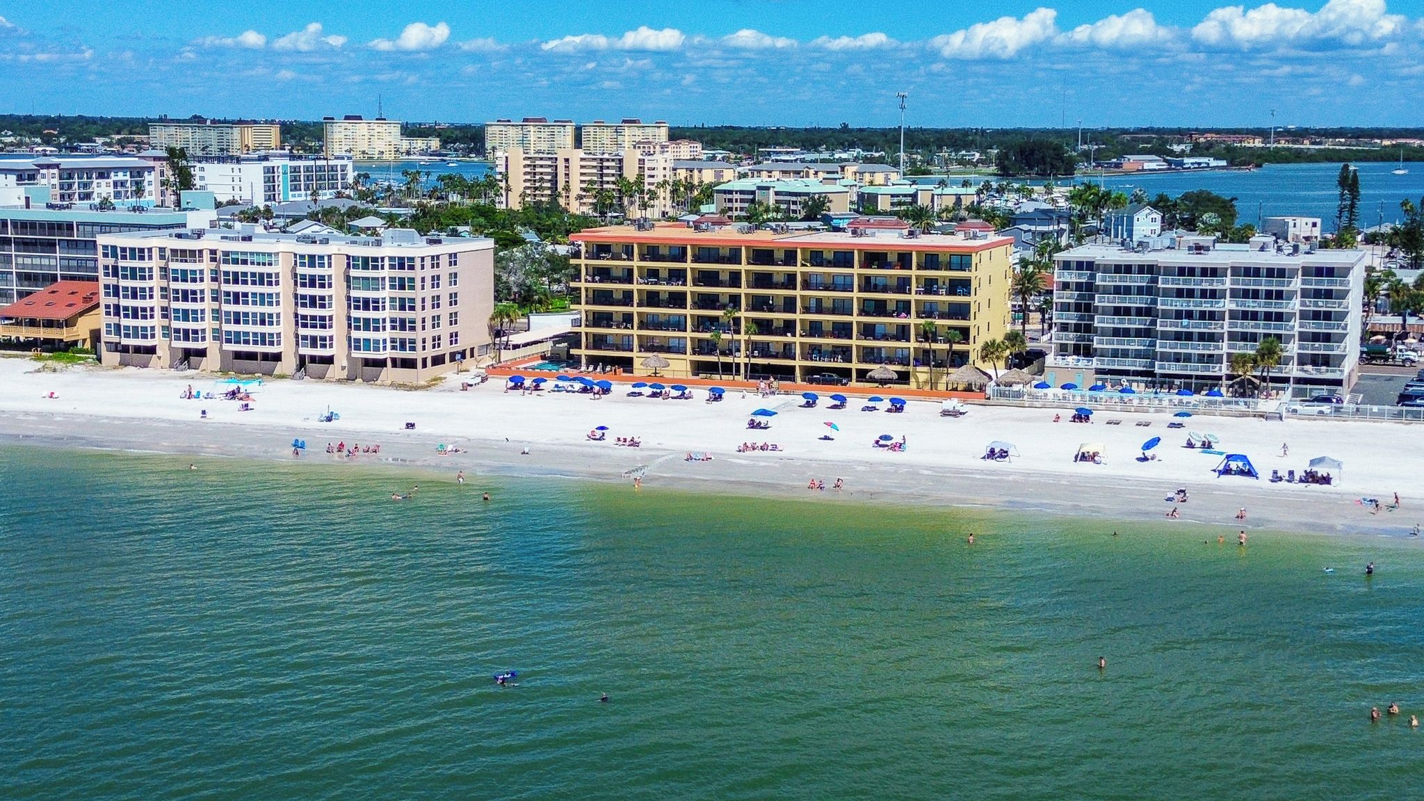 Un hotel frente al mar con varios pisos y zona de piscina.