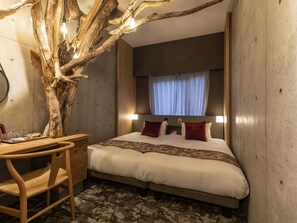 A bedroom with a large bed, a desk, and a chair. There is a tree branch with lights hanging from it. - HALE Kyoto Tambaguchi (Kyoto)