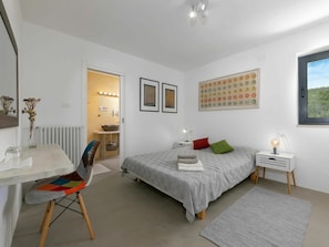 A bedroom with a bed, bedside table, chair, and a view of a bathroom. - Beautiful private villa for 6 guests with private pool, WIFI, A/C, terrace and pets allowed (Umag)