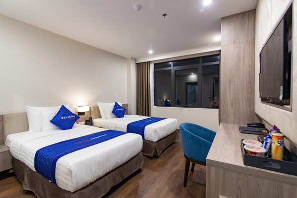 A hotel room with two beds, a desk, a chair, and a TV. - Sunshine Hotel (Mong Cai 2)