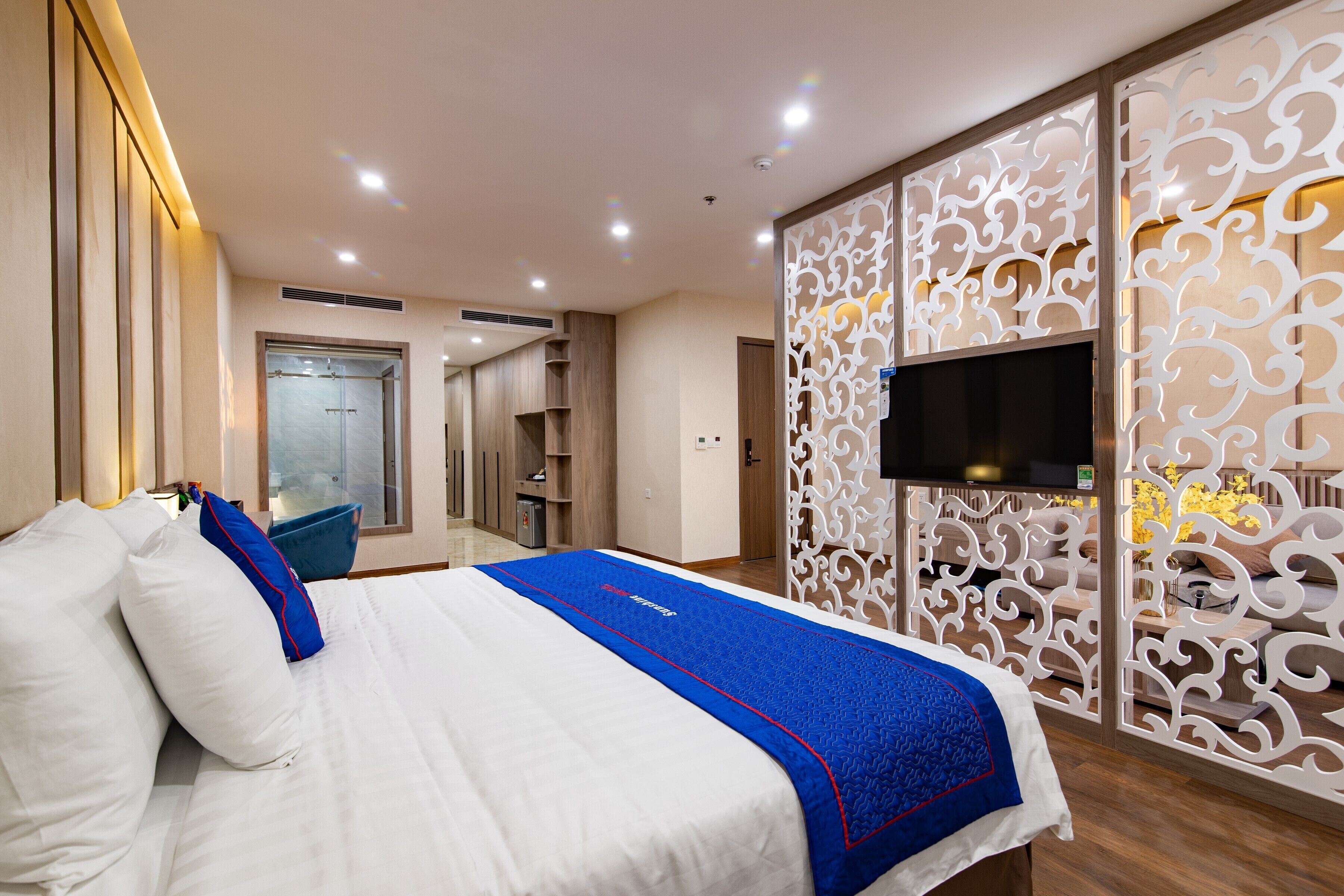A hotel room with a bed, a TV, a wardrobe, and a bathroom.
