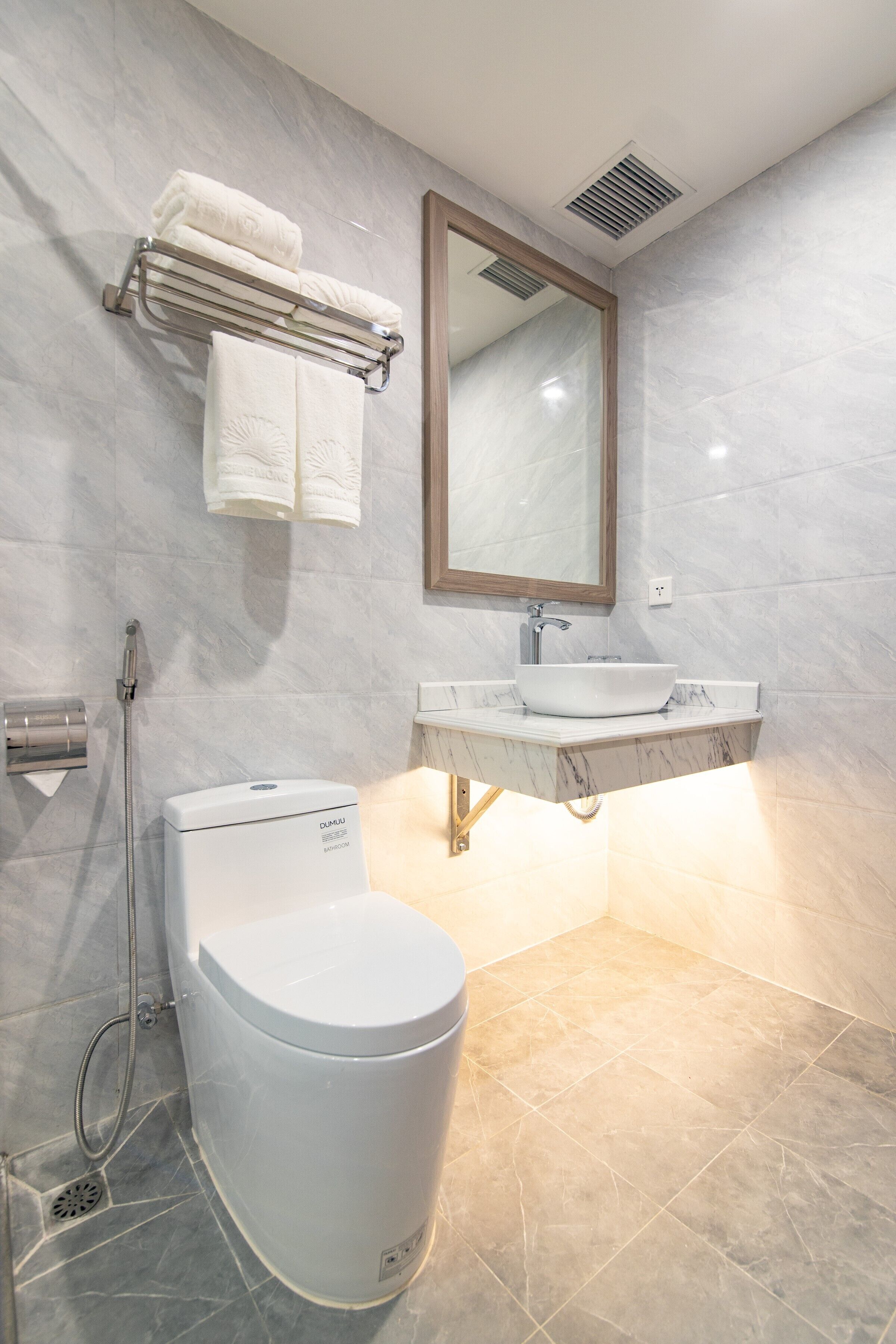 Une salle de bain moderne équipée de toilettes, d’un lavabo et d’une douche.