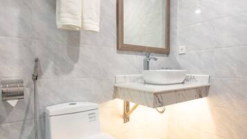 Une salle de bain moderne équipée de toilettes, d’un lavabo et d’une douche.