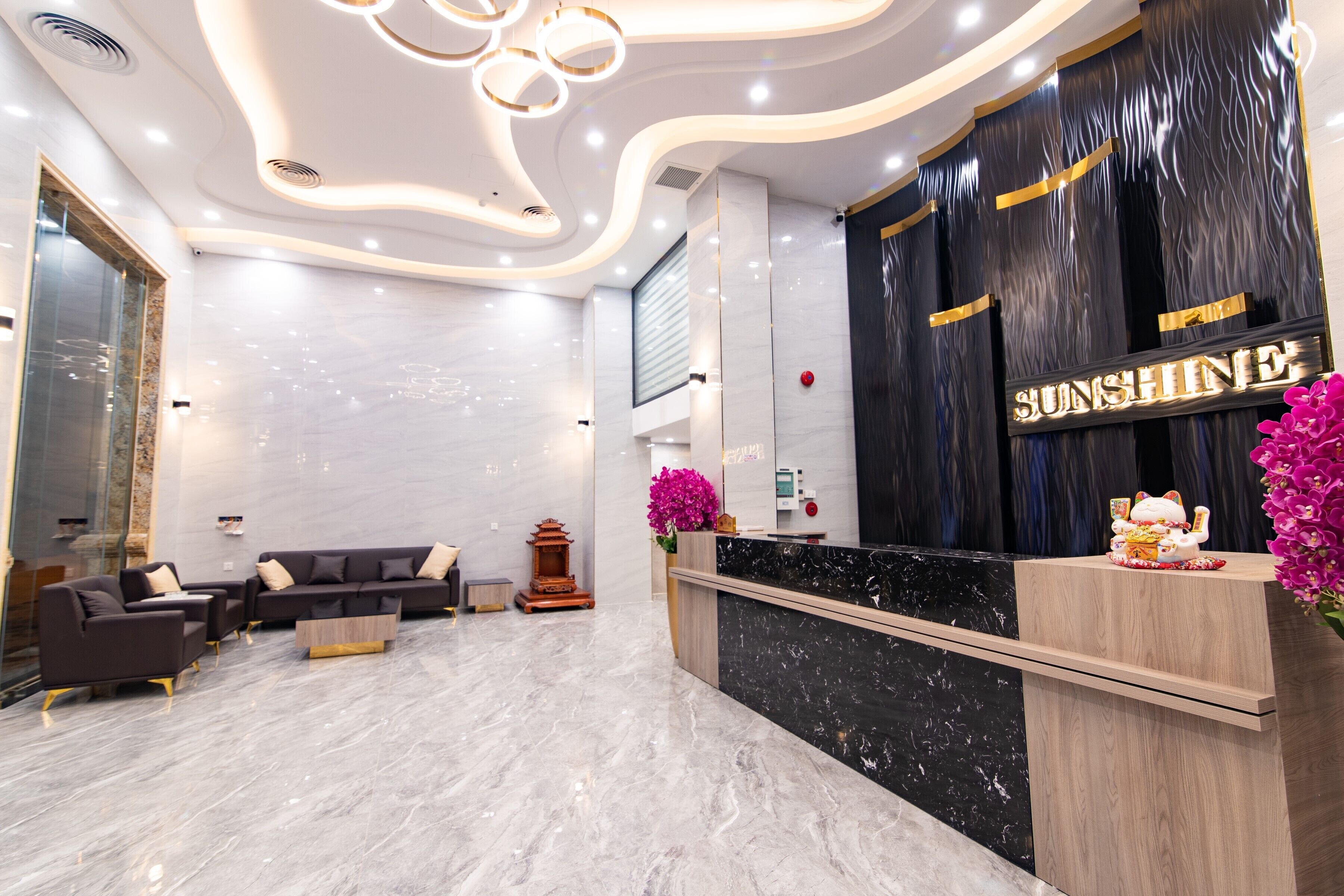 A modern reception area with a marble floor, a reception desk, and a seating area with sofas.