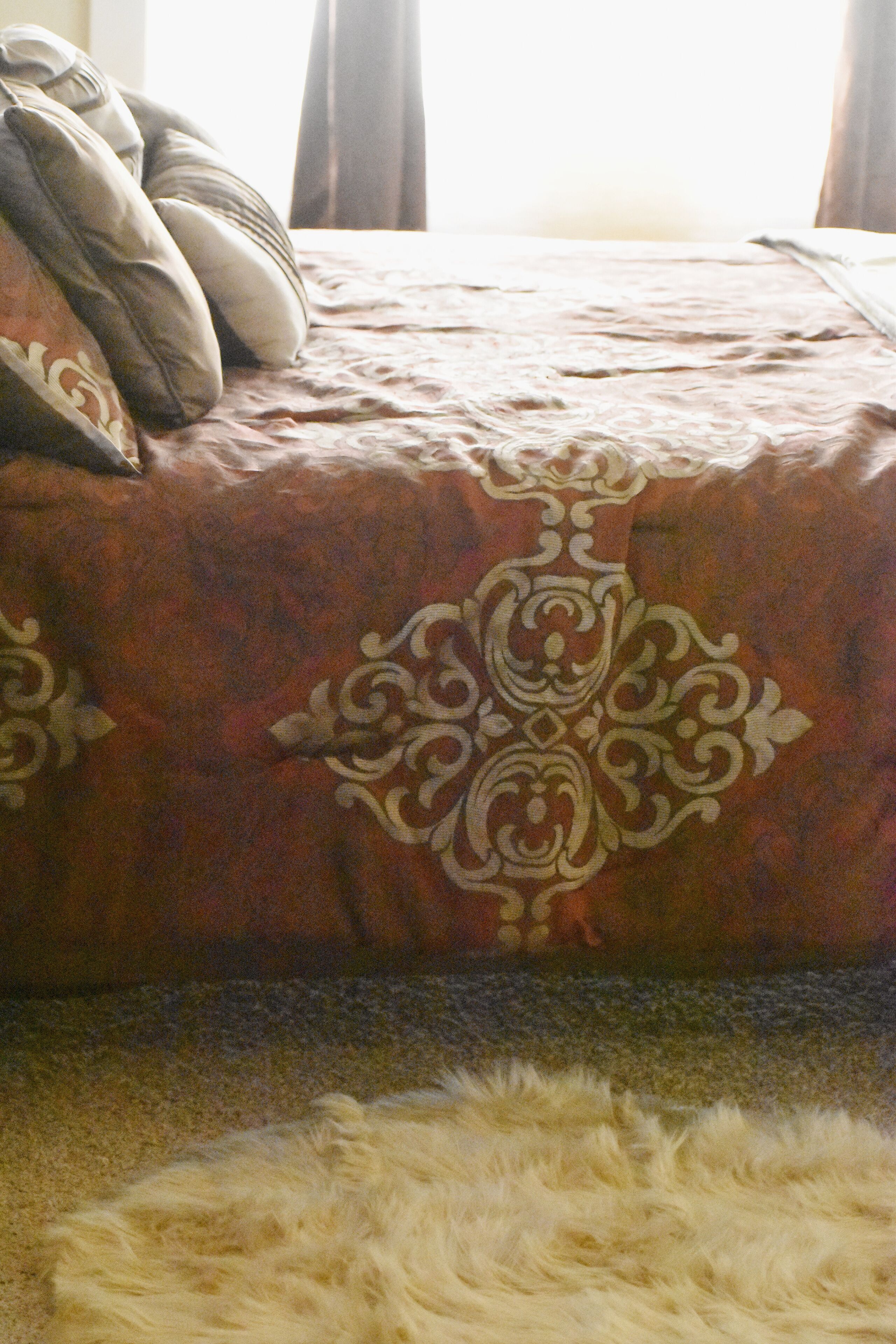 Una cama con colcha y almohadas estampadas.