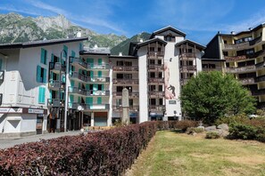 Un hôtel à plusieurs étages, doté de balcons et offrant une vue sur les montagnes.
