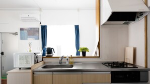 Een moderne keuken met een ingebouwde magnetron, spoelbak, kookplaat en vaatwasser.