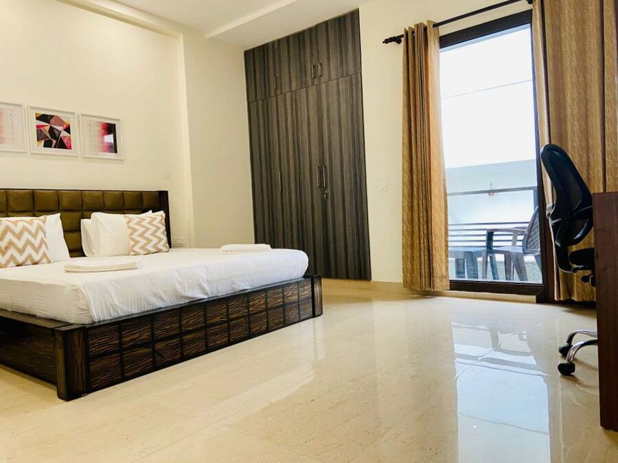 Een moderne hotelkamer met een groot bed, een kledingkast en een balkon met uitzicht.