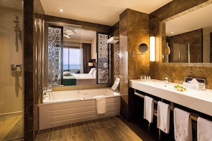 Ein modernes Badezimmer mit einer großen Badewanne, einem Doppelwaschbecken und einem großen Spiegel.