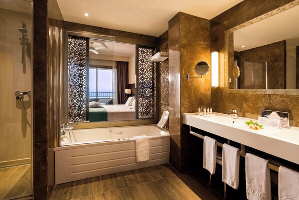 Une salle de bain moderne avec une grande baignoire, un double vasque et un grand miroir.