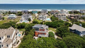 A coastal residential area with houses, a swimming pool, and a view of the ocean.