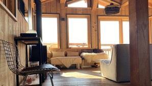 A cozy wooden interior with a sofa, a chair, and a fireplace. - Chalet Mélèze Vallée de Chamonix (Servoz)