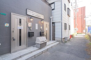 Un edificio con un letrero que dice "Merry House Sumiyoshi-Taiha" y una parrilla de barbacoa en el exterior.