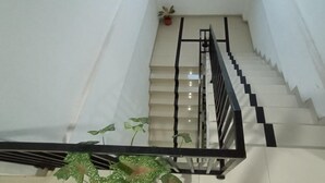Una escalera con barandilla negra y escalones blancos.