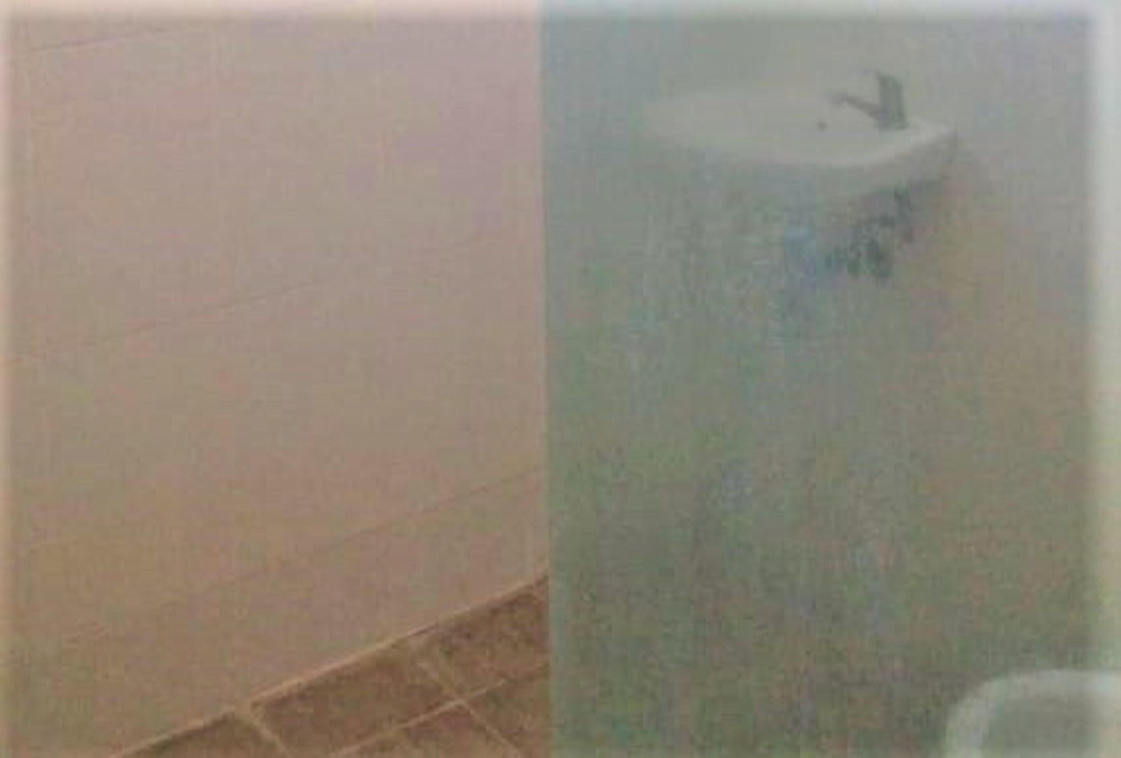 A bathroom with white tiles and a white sink.