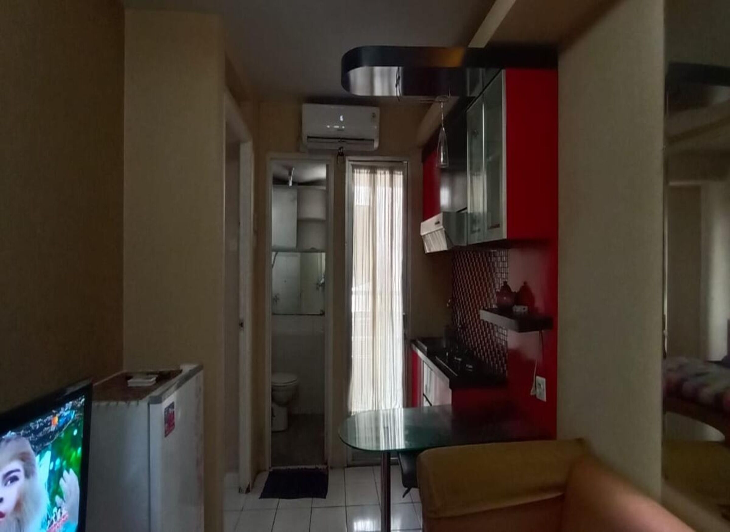 A compact living space with a kitchenette, a dining area, and a small bathroom.