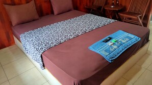 Ein Bett mit einer Decke mit Leopardenmuster, einem blauen Handtuch und einer Fernbedienung darauf.