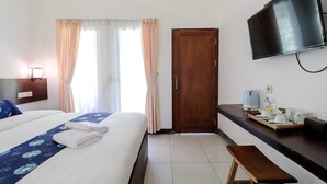 A hotel room with a bed, a wooden bench, a TV, and a kitchenette area. - Balkondes Kenalan (Borobudur)