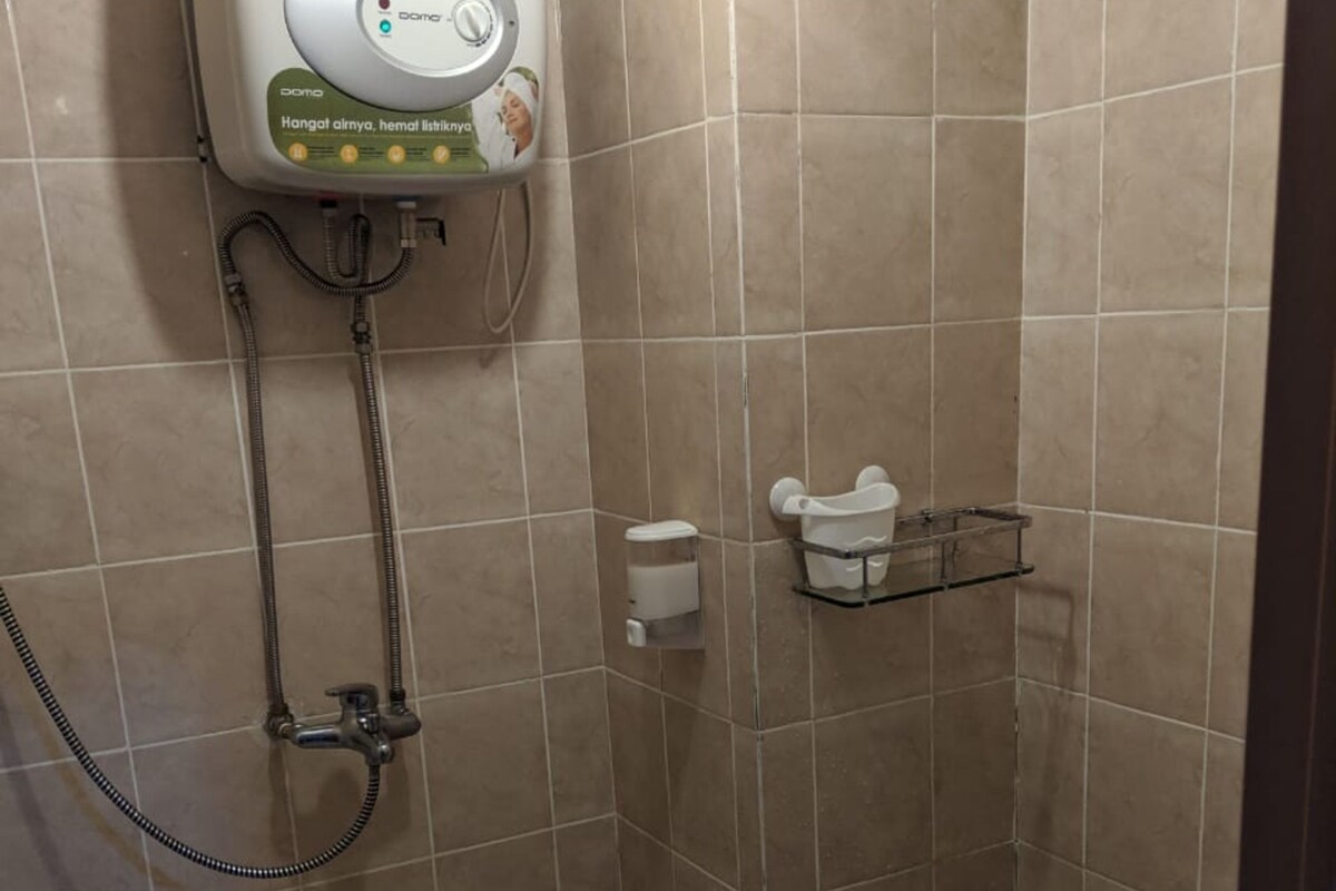 Une salle de bain équipée de toilettes, d’une douche et d’un sèche-mains.