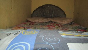 A bed with a floral bedspread and a headboard. - Hotel Kopeng Indah 1 (Getasan)