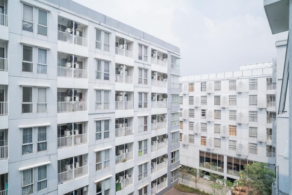 Un edificio residencial de varios pisos con balcones, ventanas amplias y unidades de aire acondicionado.