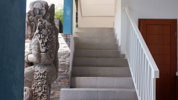 Eine Treppe mit weißer Geländer, die zu einer Holztür führt.