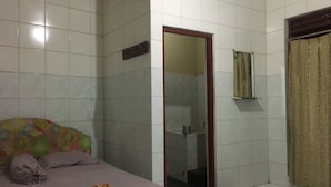 Ein Schlafzimmer mit Bett, ein Badezimmer mit Spiegel und Duschbereich.