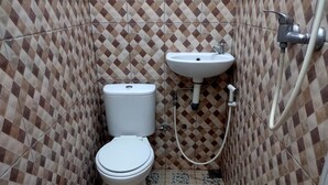 Een compacte badkamer met toilet en wastafel.