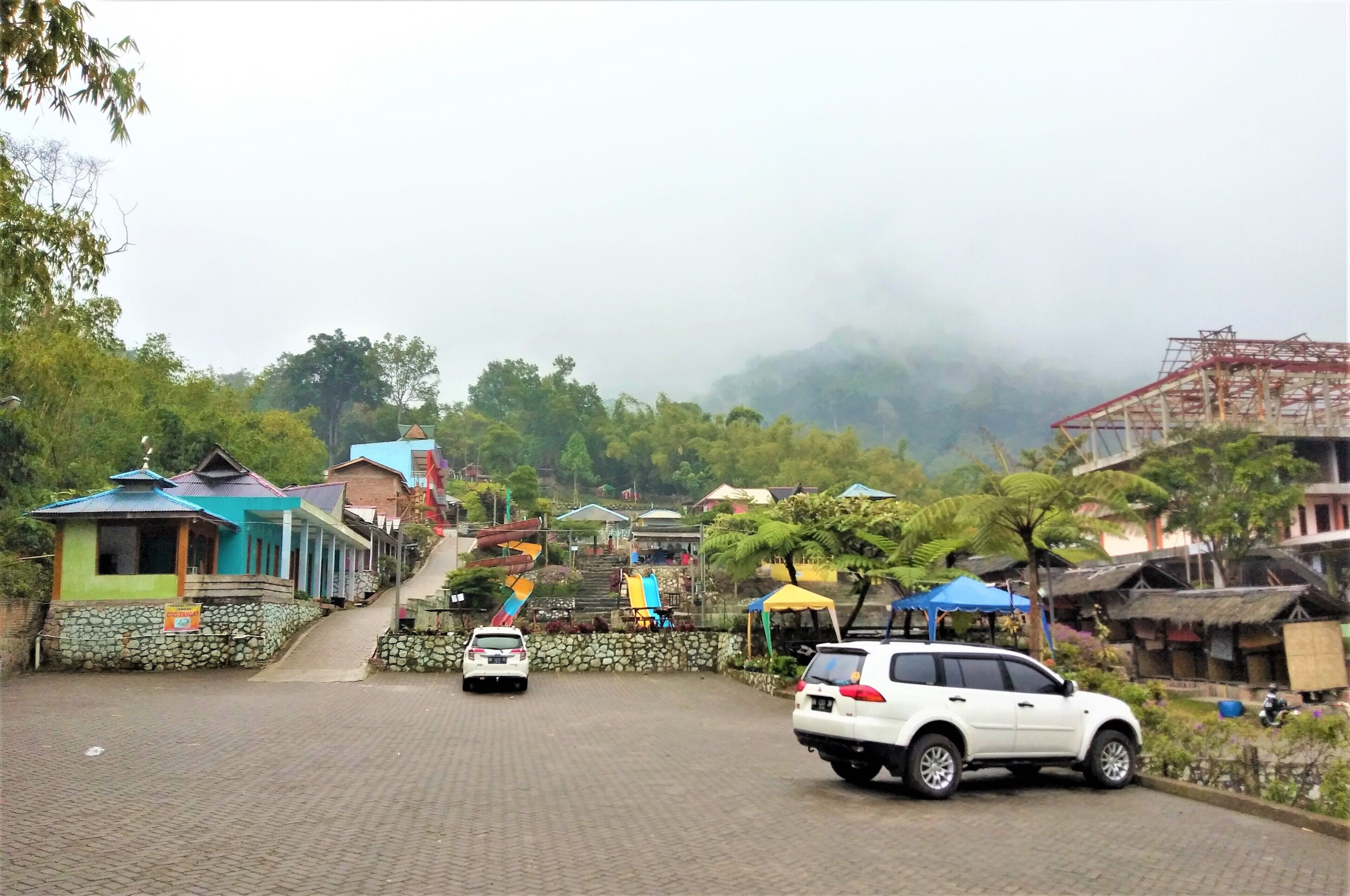 A paved road with buildings and a car.