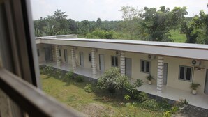 A building with a flat roof, multiple windows, and a balcony area with potted plants. - Penginapan Transit Tomato (Medan)