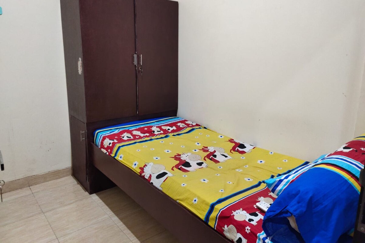 Un dormitorio con cama, armario y suelo de baldosas.