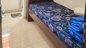 Une chambre à coucher avec un lit, une armoire, une porte et une fenêtre avec des stores.