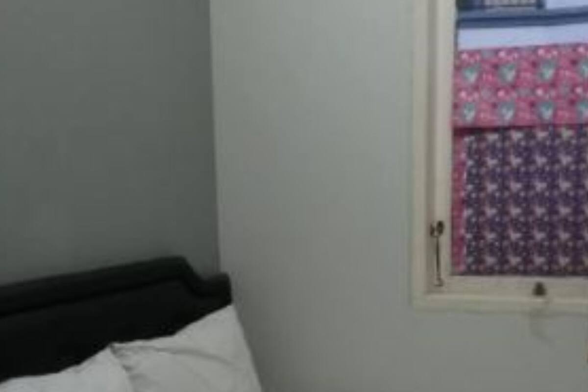 Um quarto com uma cama, uma janela e uma porta.