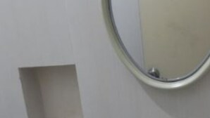 A bathroom with a white sink, a mirror, and a small shelf. - Siwalankerto F7 (Surabaya)