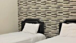 A hotel room with two single beds, a patterned wall, and a plain white wall. - Siwalankerto F7 (Surabaya)