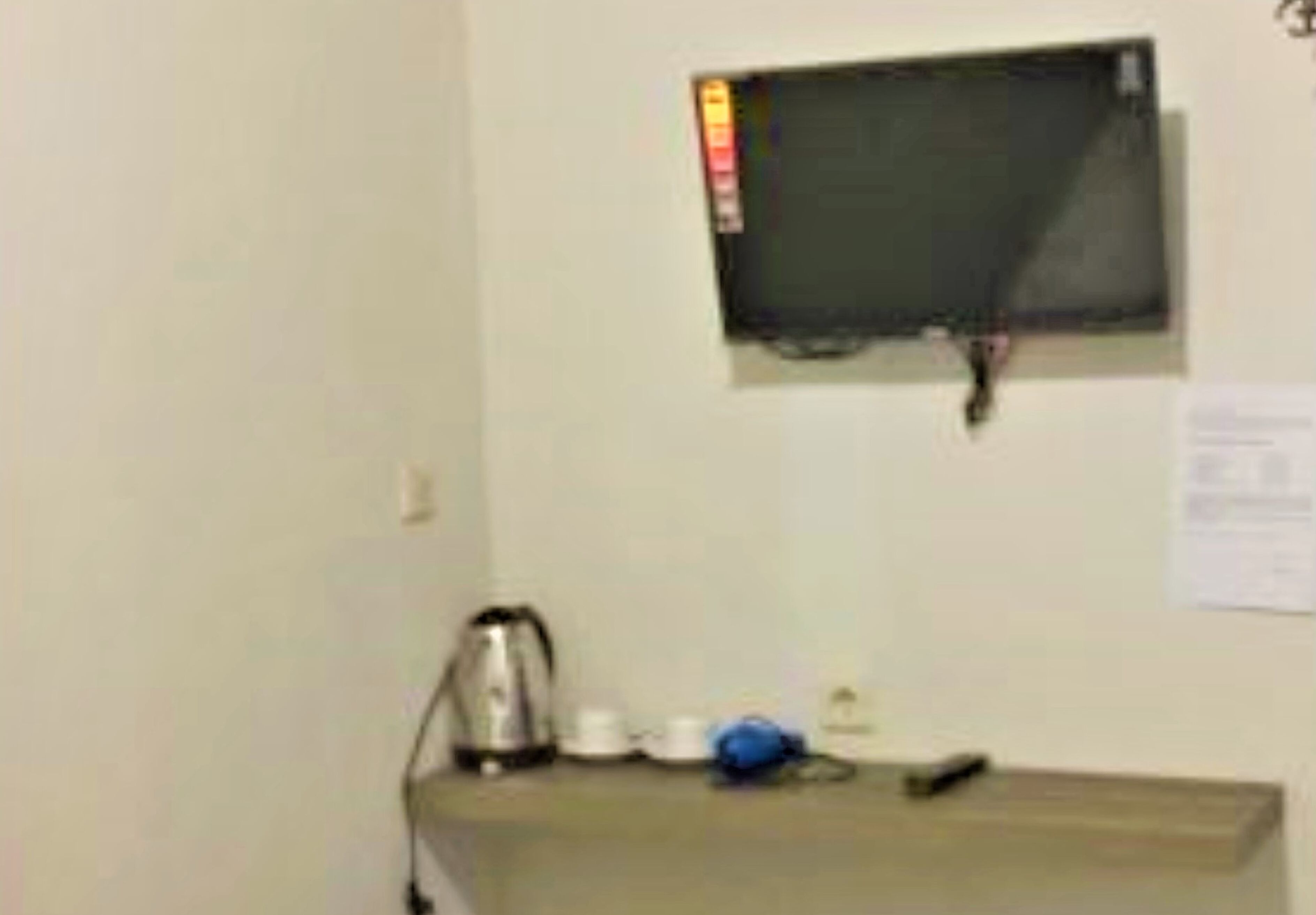 A small kitchenette with a microwave, kettle, and coffee maker on a countertop.