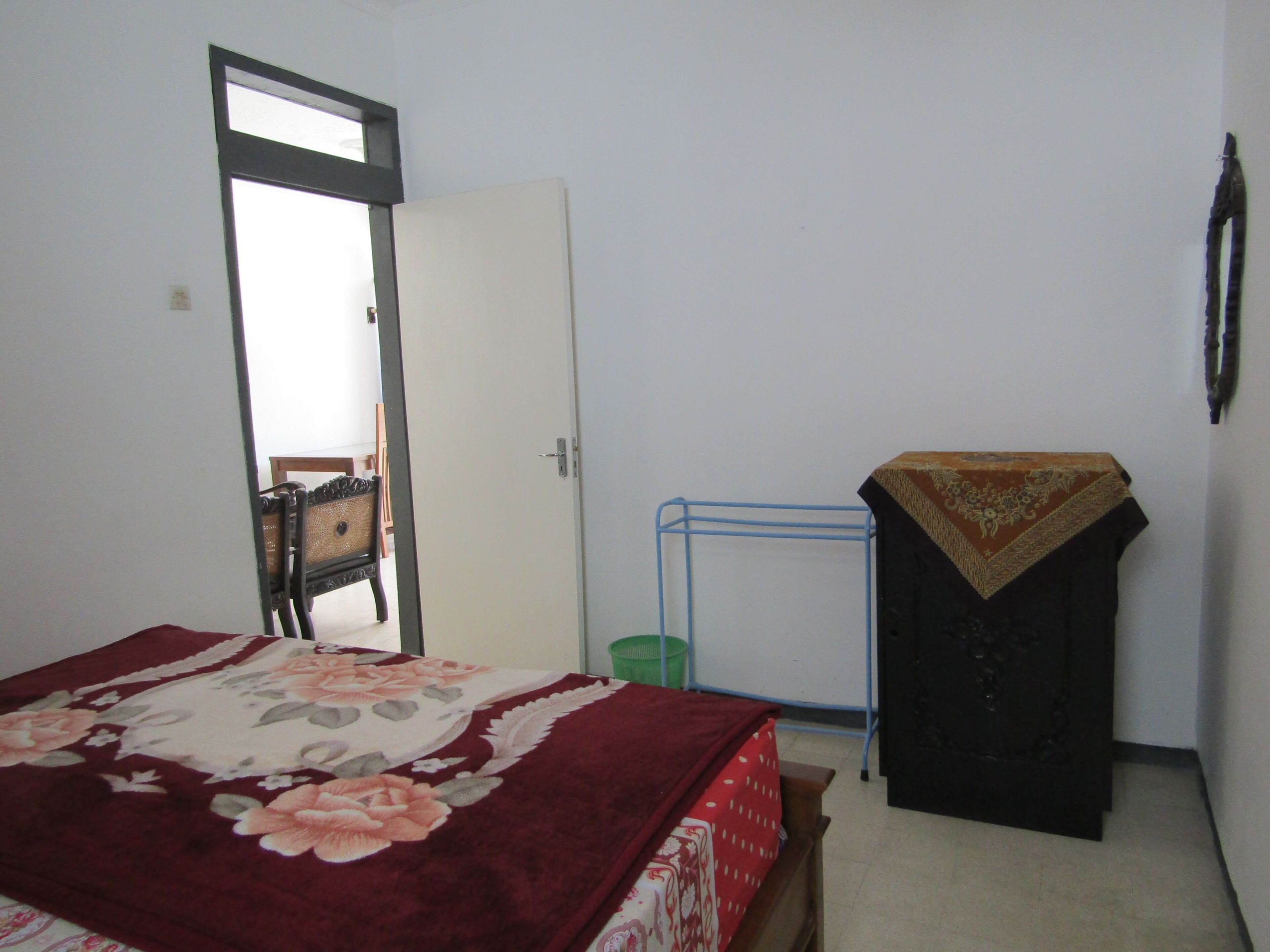 Un dormitorio con una cama, un armario, una puerta y una silla.