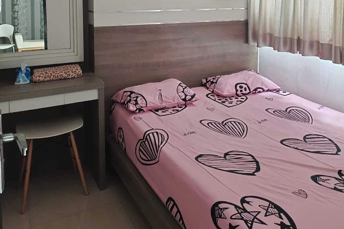 A bedroom with a bed, a desk, and a chair.