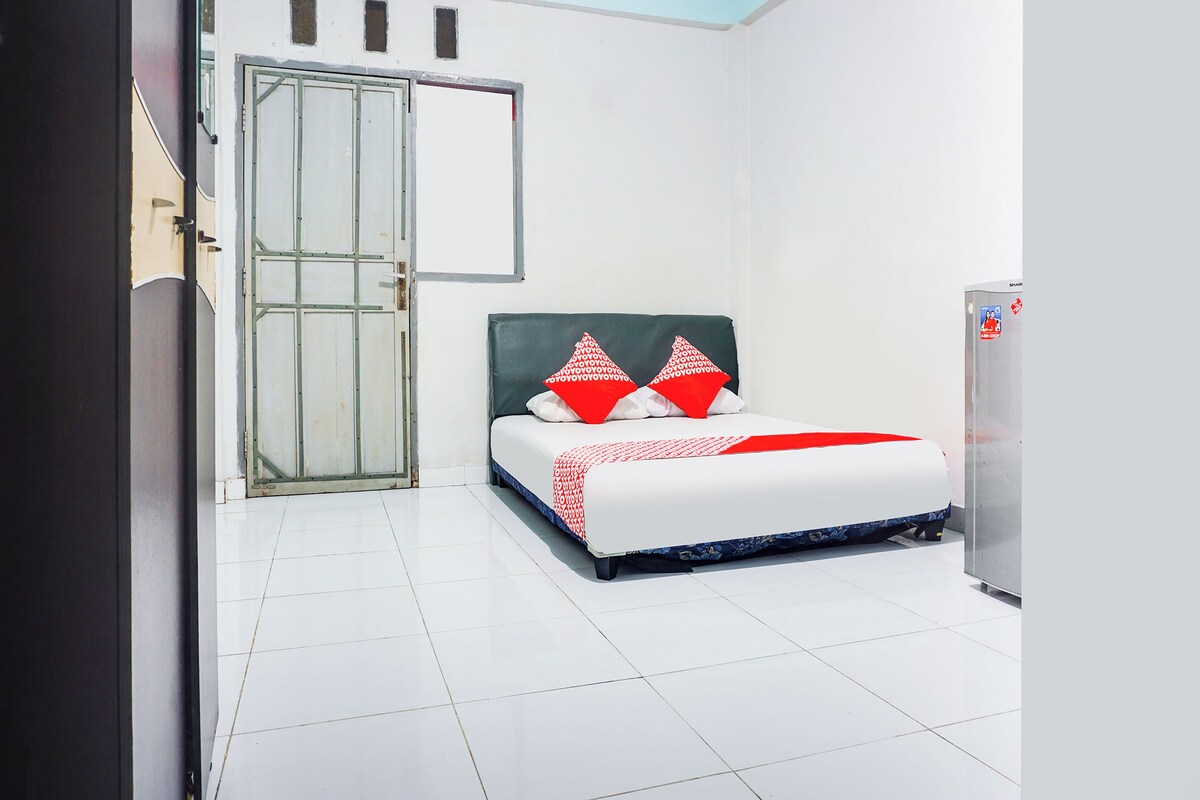 A hotel room with a bed, a wardrobe, and a door.