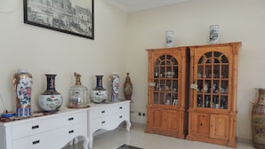 A room with a white dresser, two wooden cabinets, and a patterned rug. - Cassa Mia Villa 1 (Sleman)