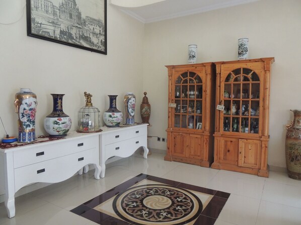 A room with a white dresser, two wooden cabinets, and a patterned rug. - Cassa Mia Villa 1 (Sleman)