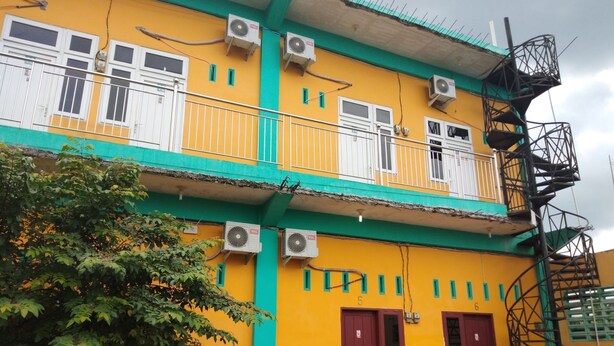 A two-story building with multiple air conditioning units, a balcony, and a staircase. - KOST 748 AT (Medan)