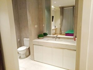A modern bathroom with a toilet, sink, and mirror. - Group Villa Luxury (Batu)